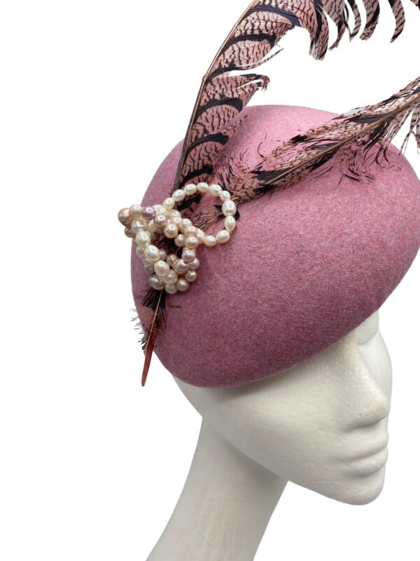 Pink felt headpiece with feathered detail.